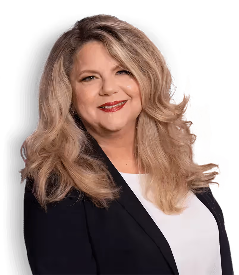 Smiling woman with long wavy blonde hair wearing a black blazer and white top.