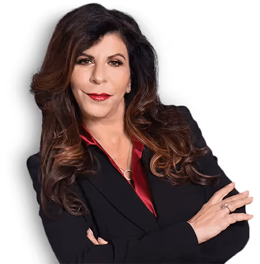Confident woman with long wavy brown hair in a black blazer over a red blouse, arms crossed.