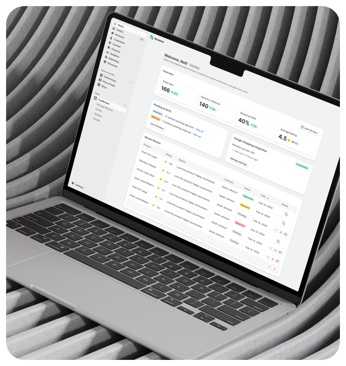 Laptop on a gray textured surface displaying a user dashboard with stats, activity summary, and recent events.