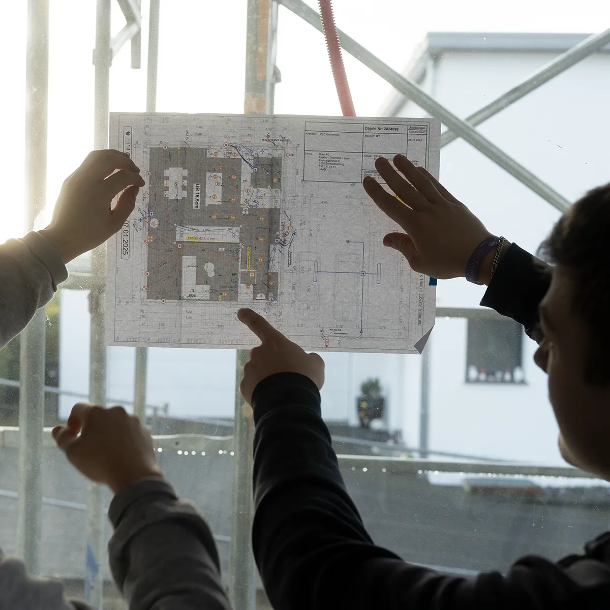Elektroinstallateure EFZ besprechen einen Elektroplan auf der Baustelle