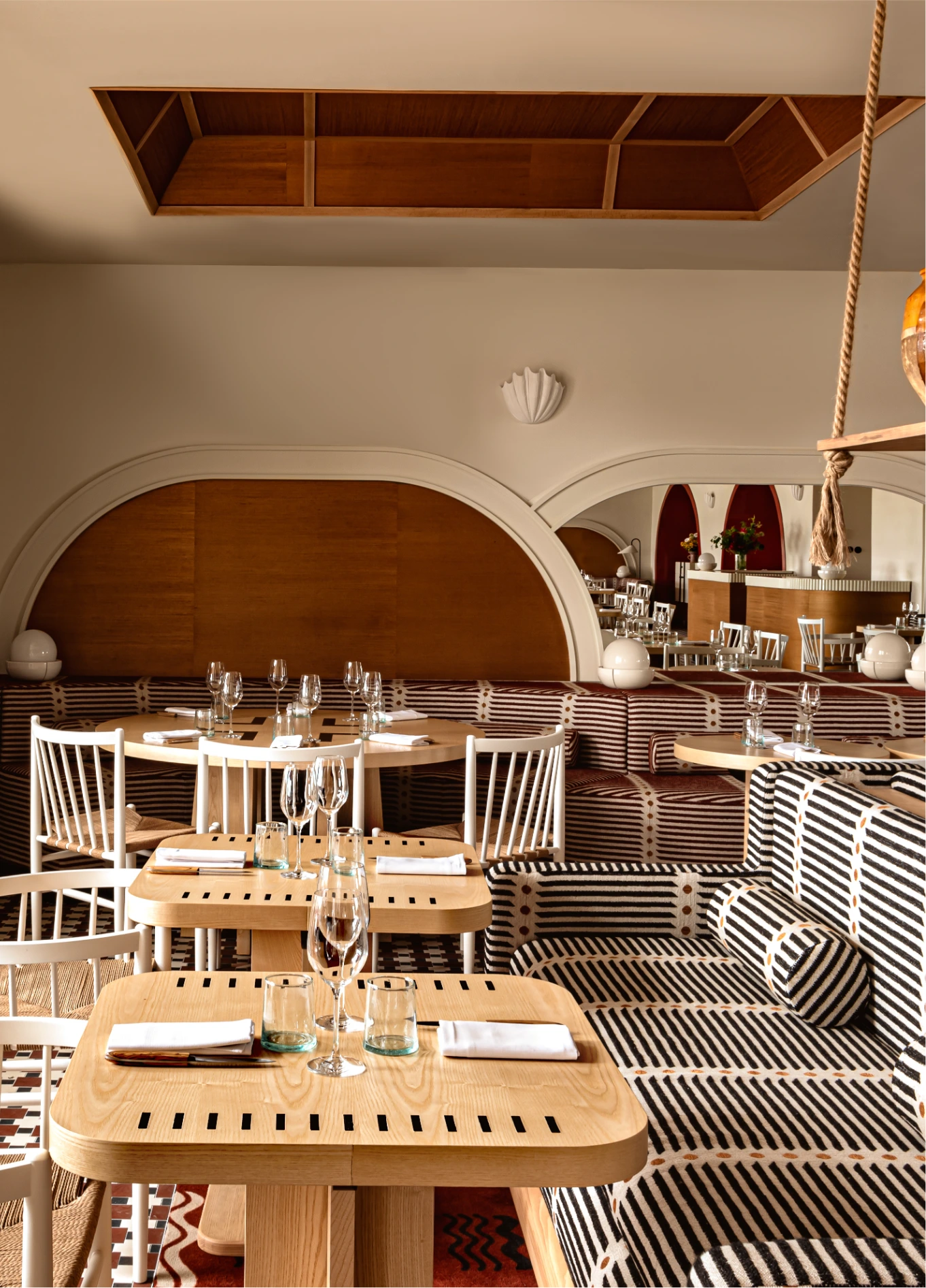 Refined interior of the Regina Experimental hotel restaurant, featuring wooden tables and comfortable seating in a warm atmosphere.