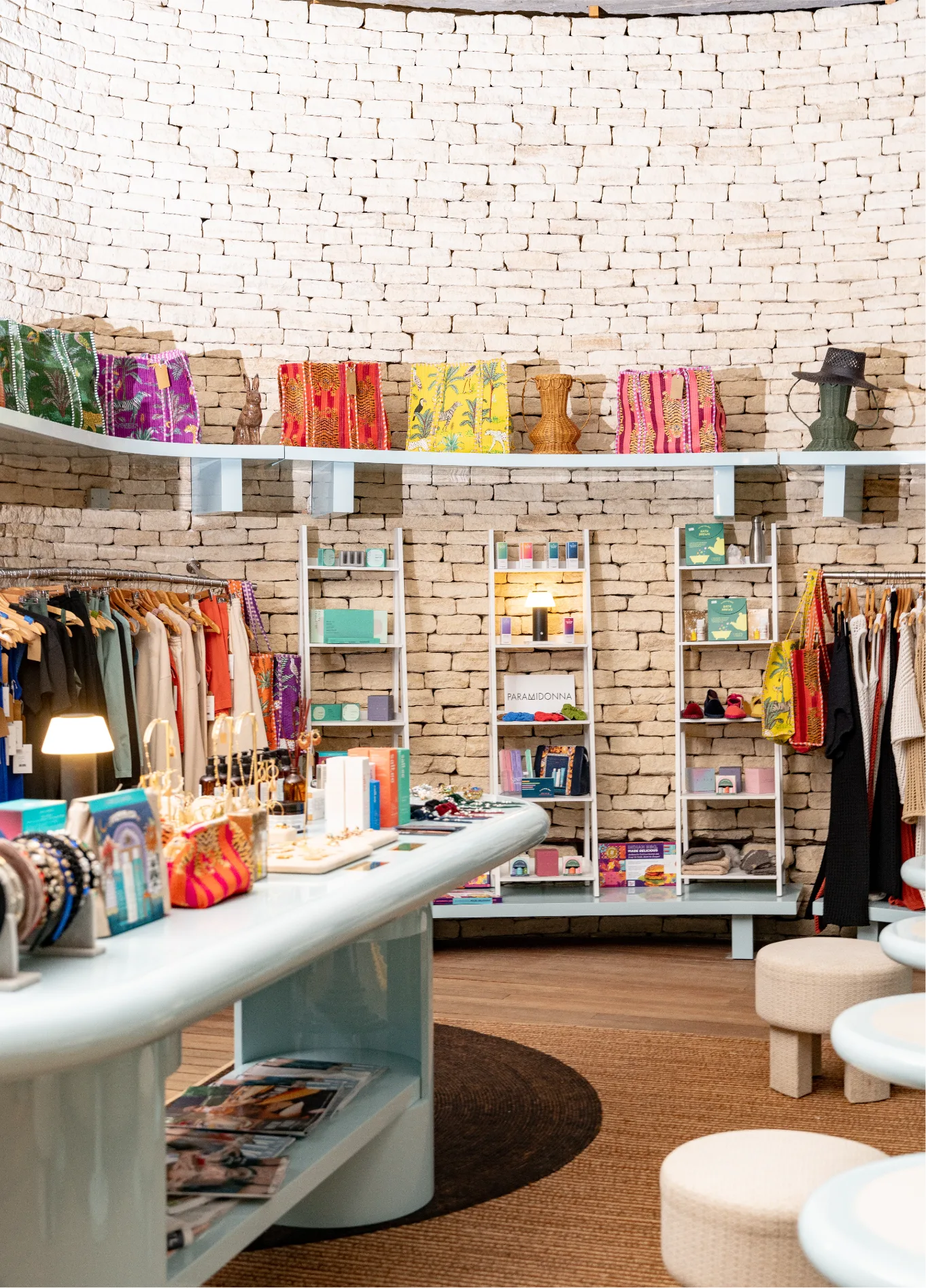 Colourful interior with clothing and shelves at Cowley Manor boutique, Cotswolds