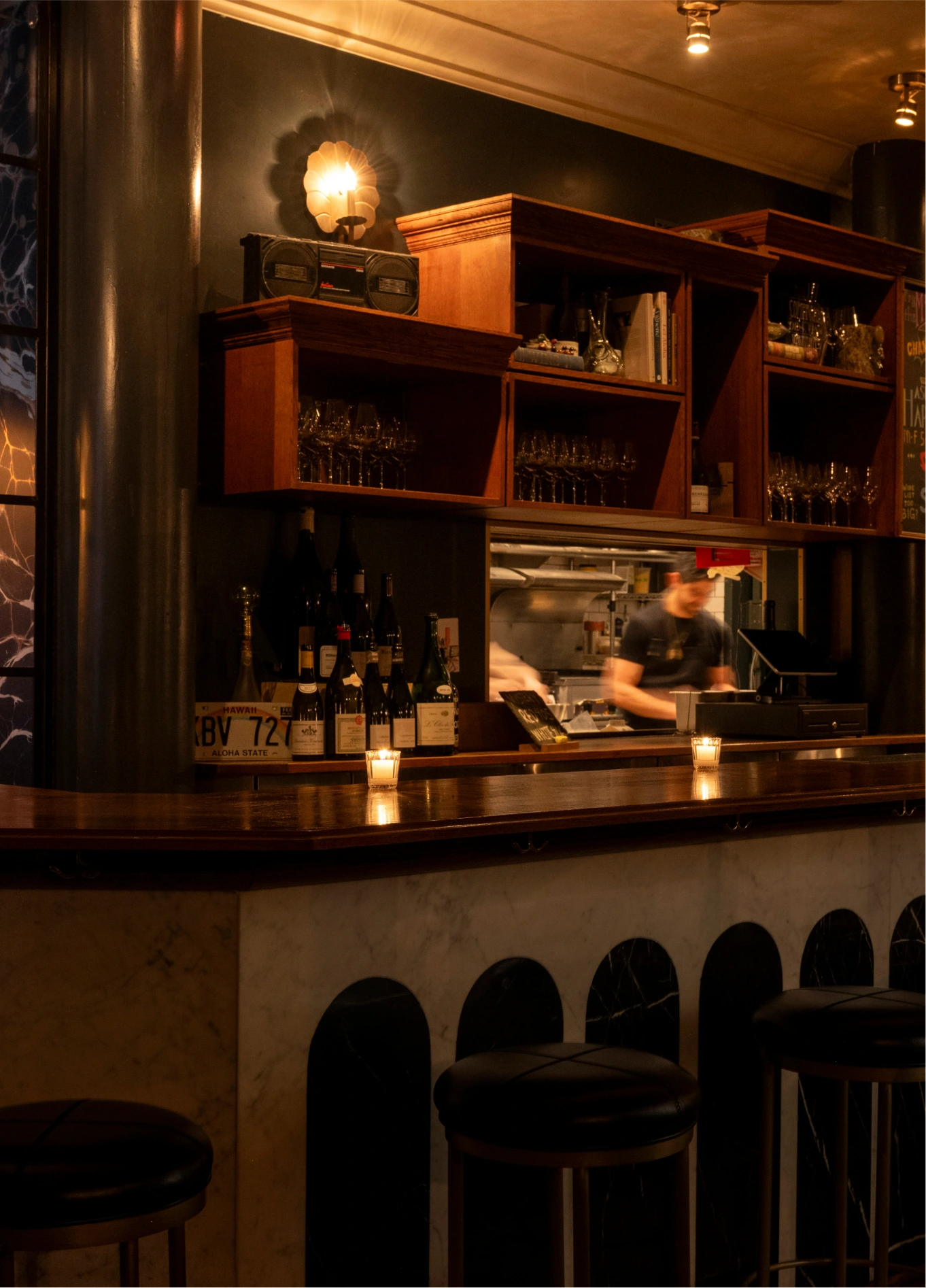 Elegant bar counter with wooden shelves and dim lighting at La Compagnie Wine Bar.
