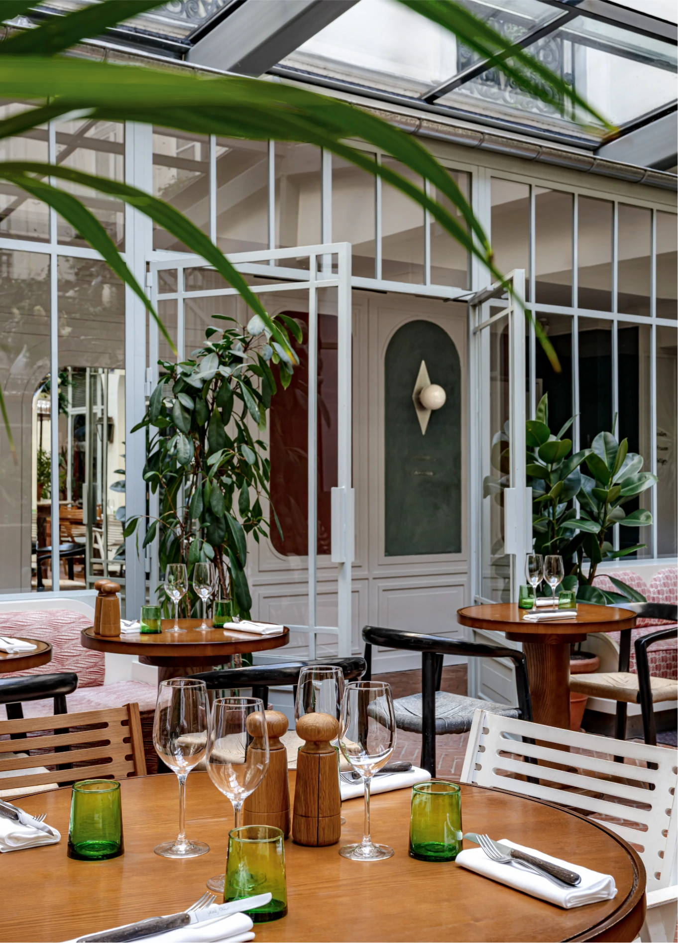 Bright restaurant dining room with glass roof and tropical plants at Grands Boulevards Experimental, Paris 2