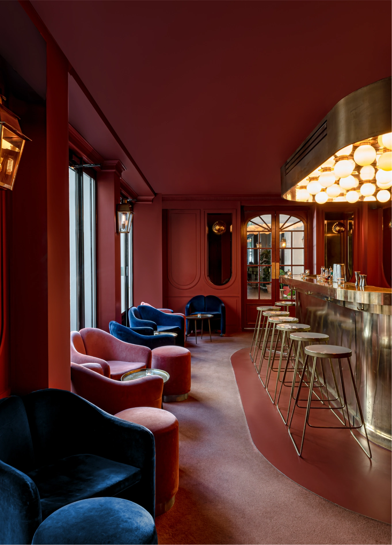 Red velvet lounge with dim lighting at The Shell cocktail bar, Grands Boulevards Experimental, Paris