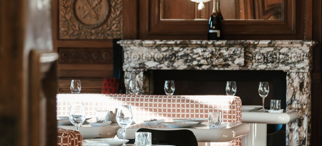 Elegant restaurant at Cowley Manor Experimental, featuring marble fireplace centerpiece.