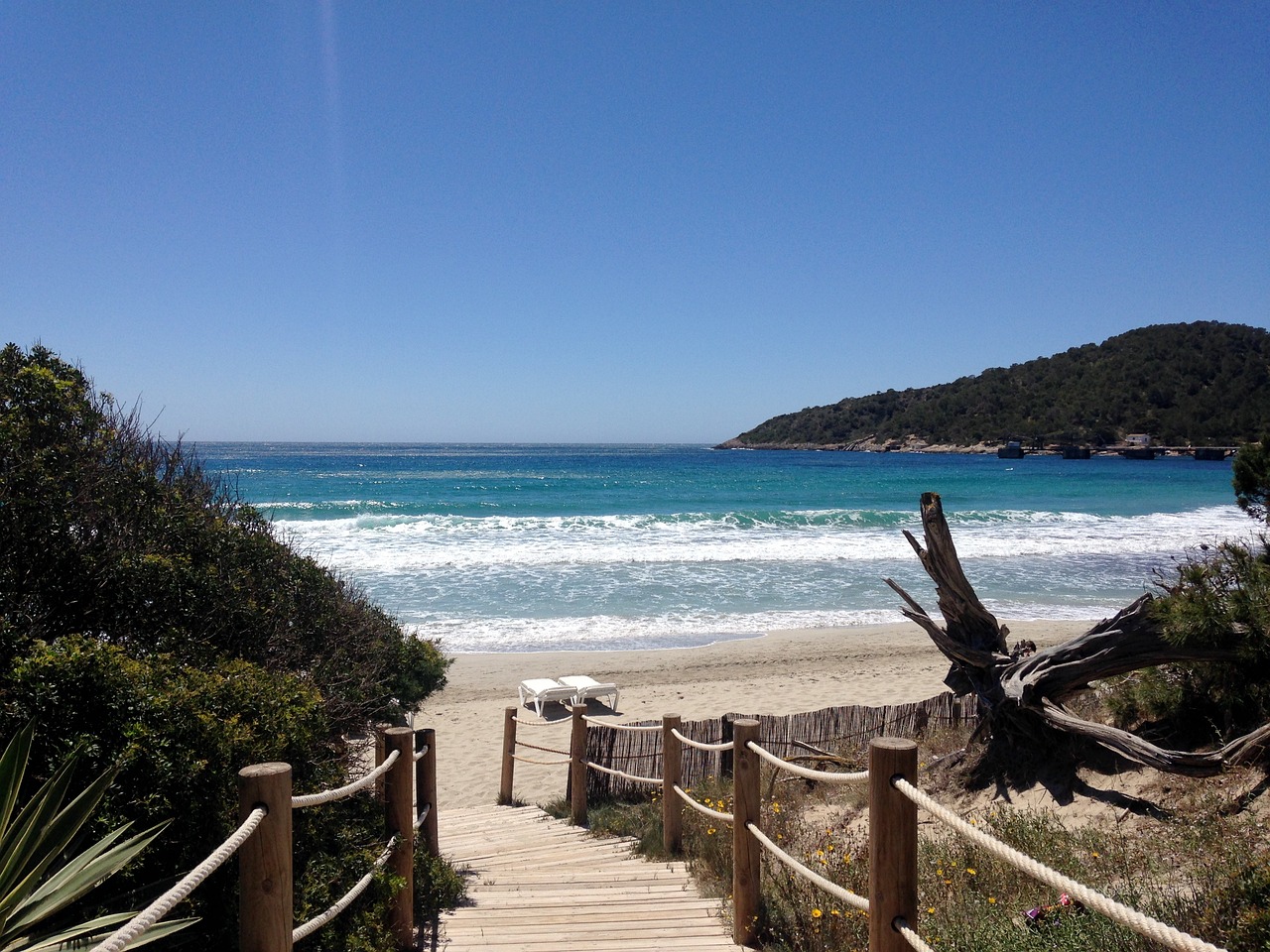 Scenic view of the best beach in Ibiza near the Montesol Hotel, showcasing pristine waters and vibrant beach activities.