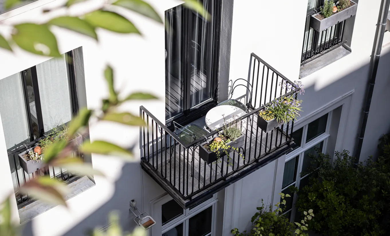 Balcon parisien privé avec chaises de jardin et vue sur la façade de l'immeuble et la verdure dans la chambre Saint Fiacre Balcony de Grands Boulevards Experimental, hôtel boutique proche de l'Opéra Garnier, Paris 2e