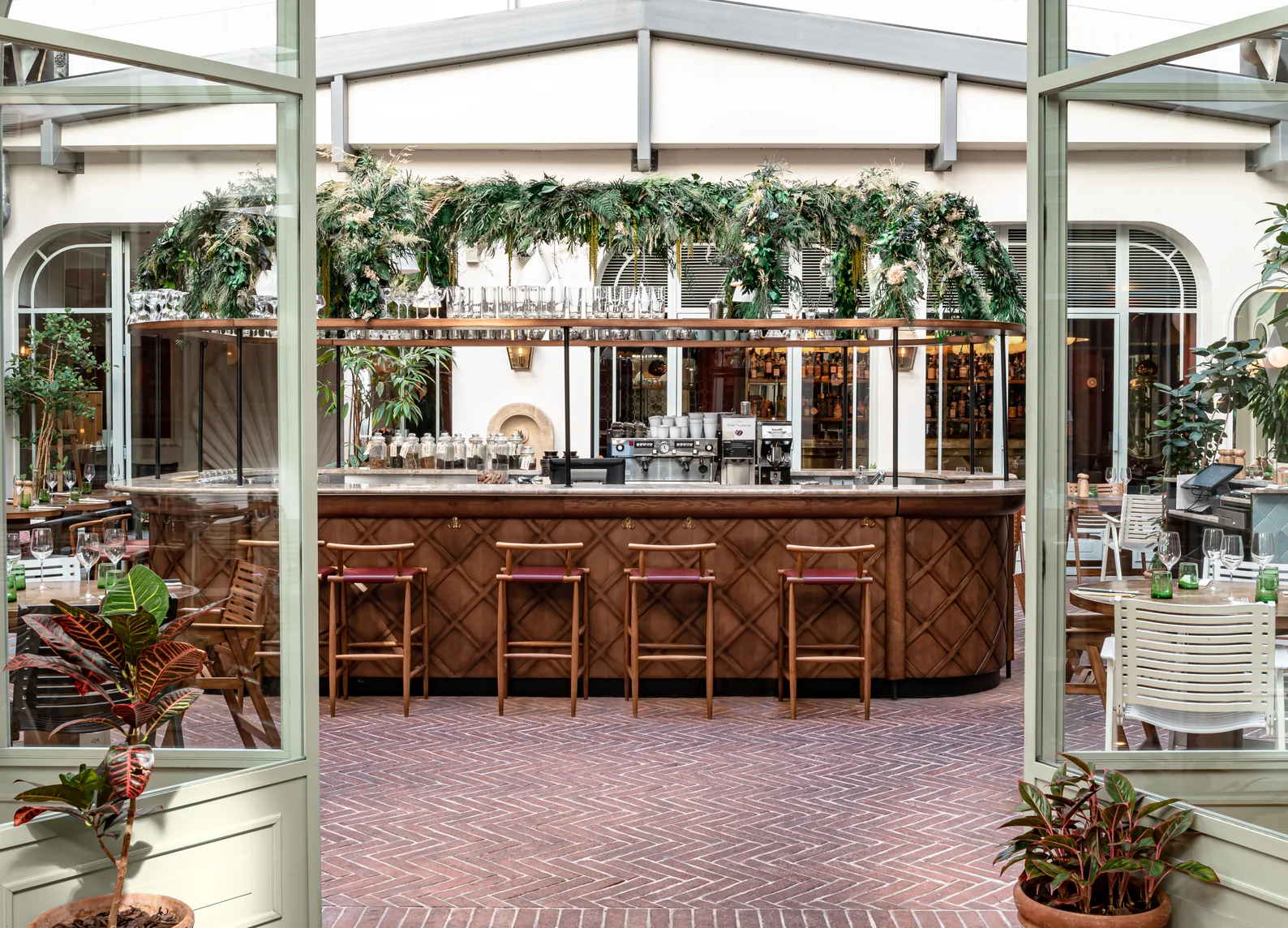 Barra de bar de madera con vegetación colgante en el restaurante con jardín del Grands Boulevards Experimental, hotel boutique en el distrito 2 de París