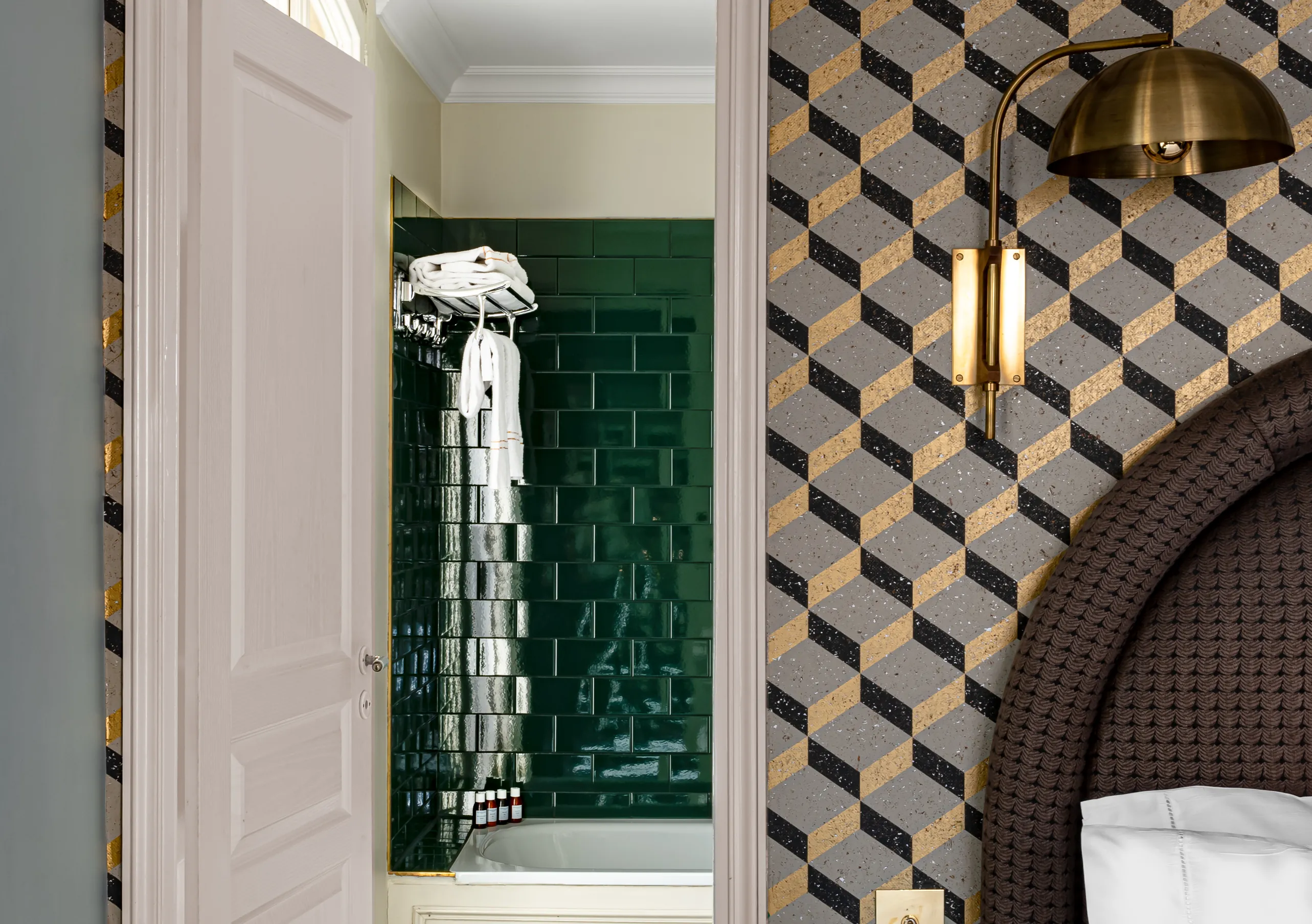 Détail de salle de bain avec carrelage vert foncé, mur à motifs géométriques et suspension dorée dans la chambre Grand Pigalle de Grand Pigalle Experimental, hôtel boutique dans le 9e arrondissement de Paris, Pigalle
