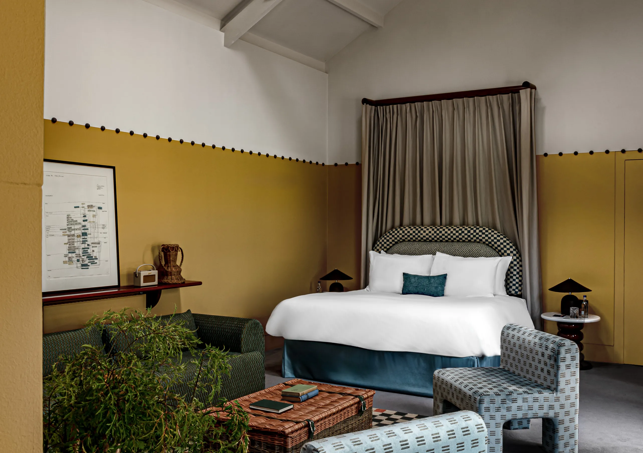 Chambre avec lit à baldaquin, murs jaune moutarde et plantes d'intérieur dans la chambre Wildflower de Cowley Manor Experimental, Cotswolds