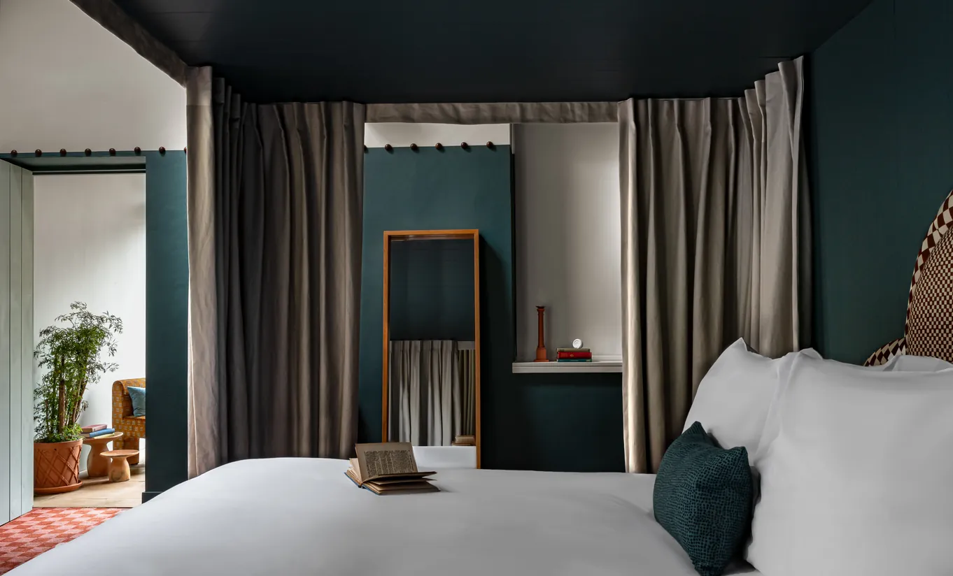 Chambre avec grand lit blanc, murs bleu canard et pots en terre cuite près de la fenêtre dans la Chambre Alpaga de Cowley Manor Experimental, Cotswolds