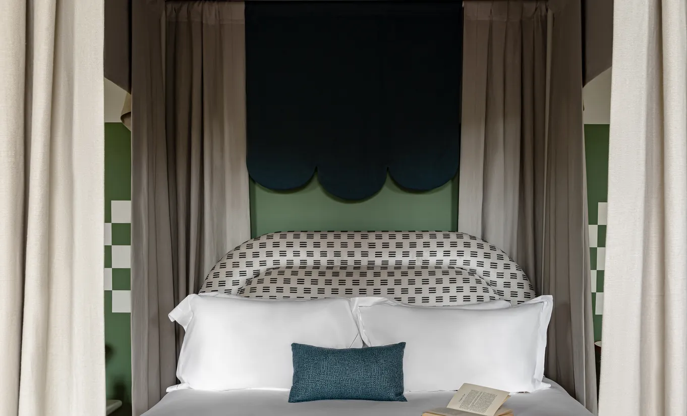 Chambre avec lit à baldaquin, ciel de lit vert sauge et tête de lit à motifs dans la St Mary Suite de Cowley Manor Experimental, hôtel de luxe dans les Cotswolds