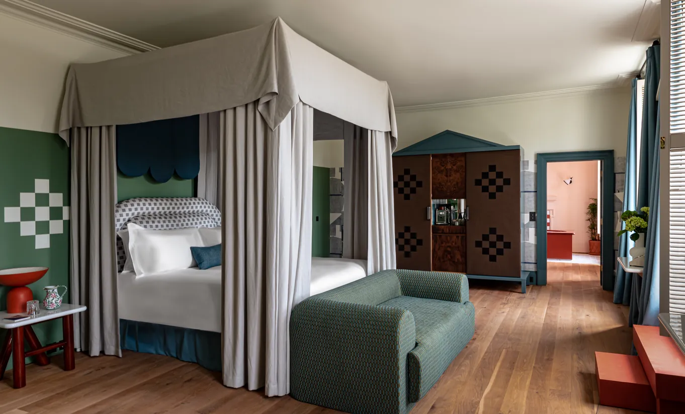 Chambre avec lit à baldaquin et parquet en bois dans la Cowley Manor Suite de Cowley Manor Experimental, hôtel spa de luxe dans les Cotswolds