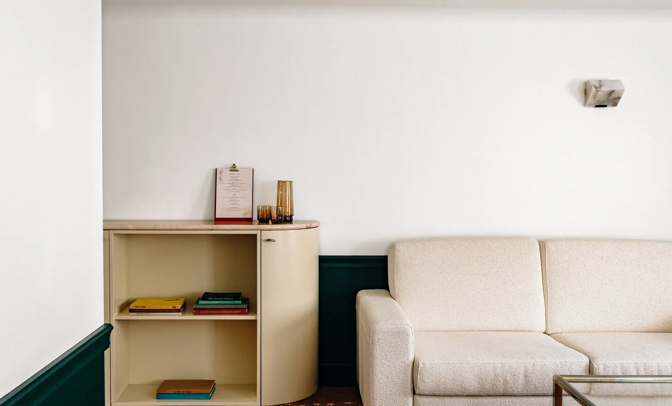 Compact living area with a beige sofa and wooden shelving in the Junior Suite at Experimental Chalet Verbier