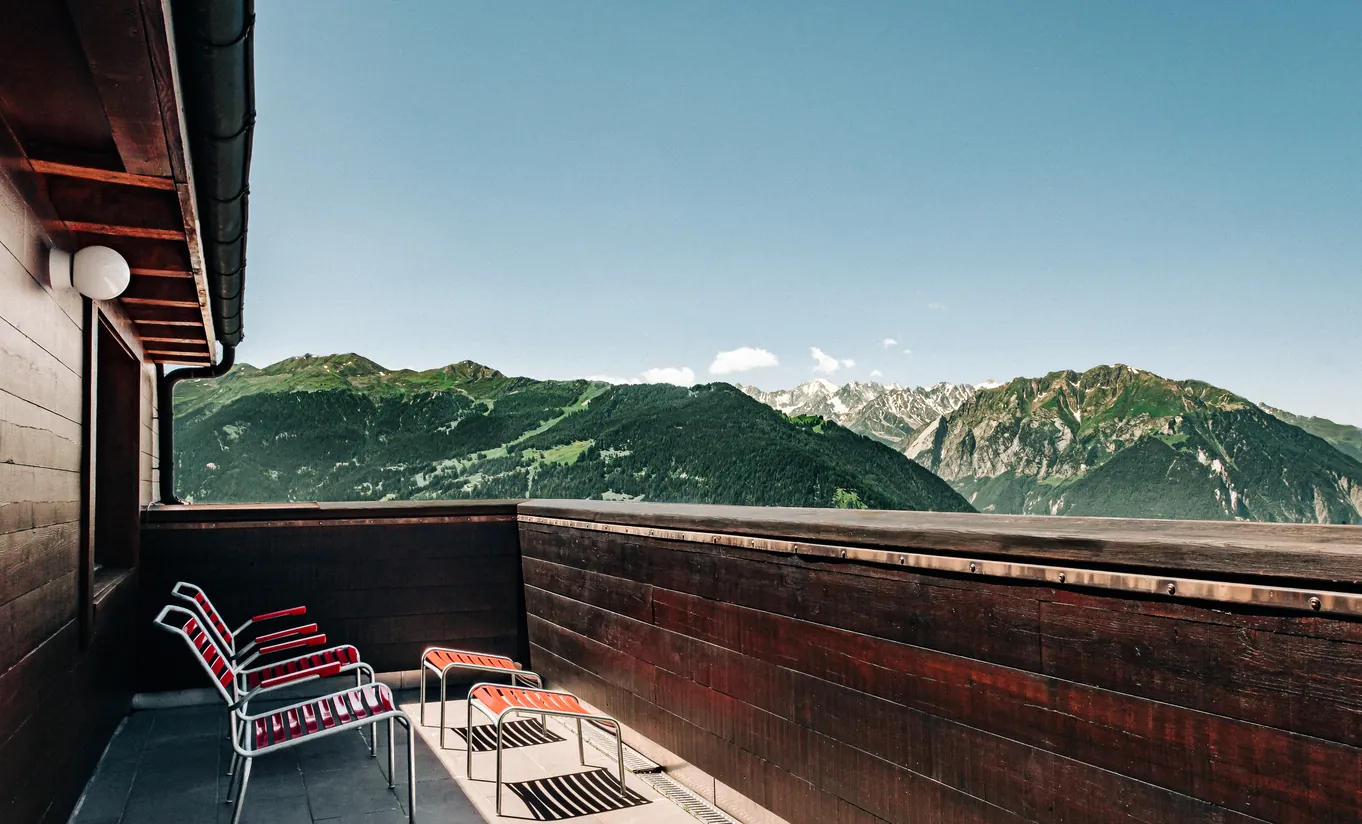 Panoramic view of the Swiss Alps from the wooden terrace of the Panorama Suite at Experimental Chalet Verbier
