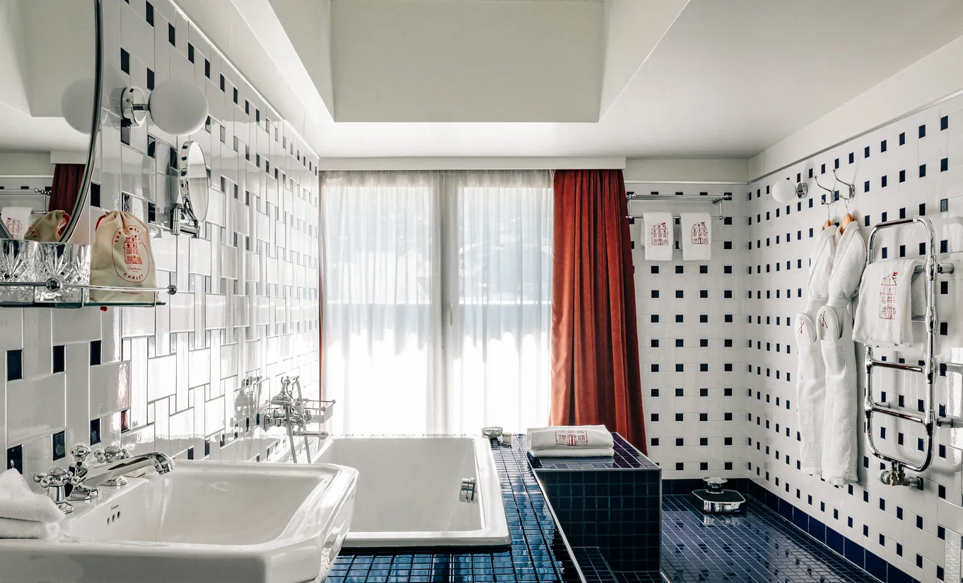 Bathroom with a freestanding bathtub and geometric tiled walls in the Panorama Suite at Experimental Chalet Verbier