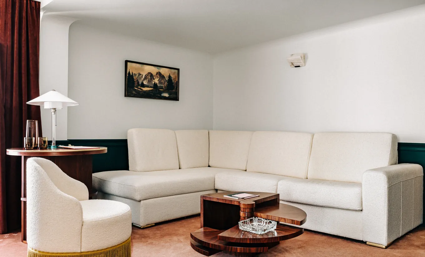 Spacious living room with a white L-shaped sofa and wooden coffee table in the Panorama Suite at Experimental Chalet Verbier
