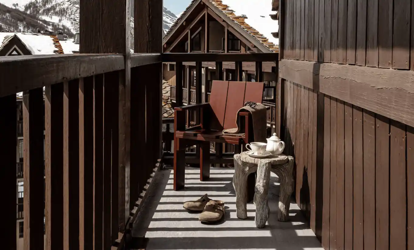 Wooden balcony with chairs and a view of alpine rooftops in the Loft with Balcony at Experimental Chalet Val d'Isère