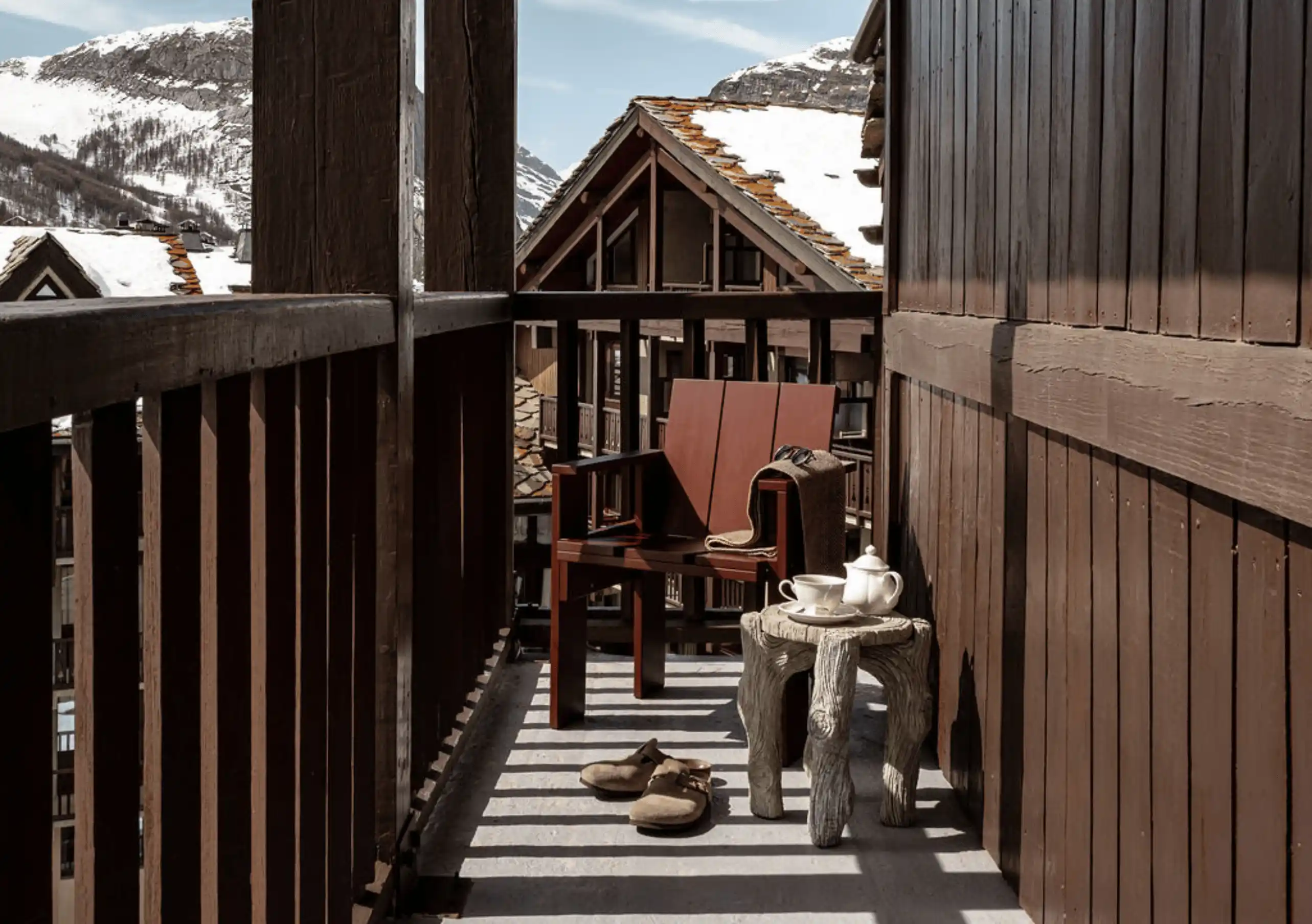 Wooden balcony with chairs and a view of alpine rooftops in the Loft with Balcony at Experimental Chalet Val d'Isère