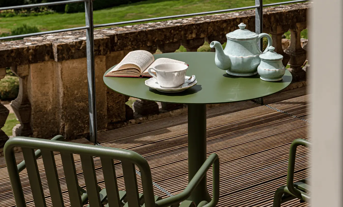 Terrasse en bois avec chaises de jardin et service à thé donnant sur la campagne verdoyante des Cotswolds dans la St Mary Suite de Cowley Manor Experimental, idéal pour une escapade romantique à la campagne