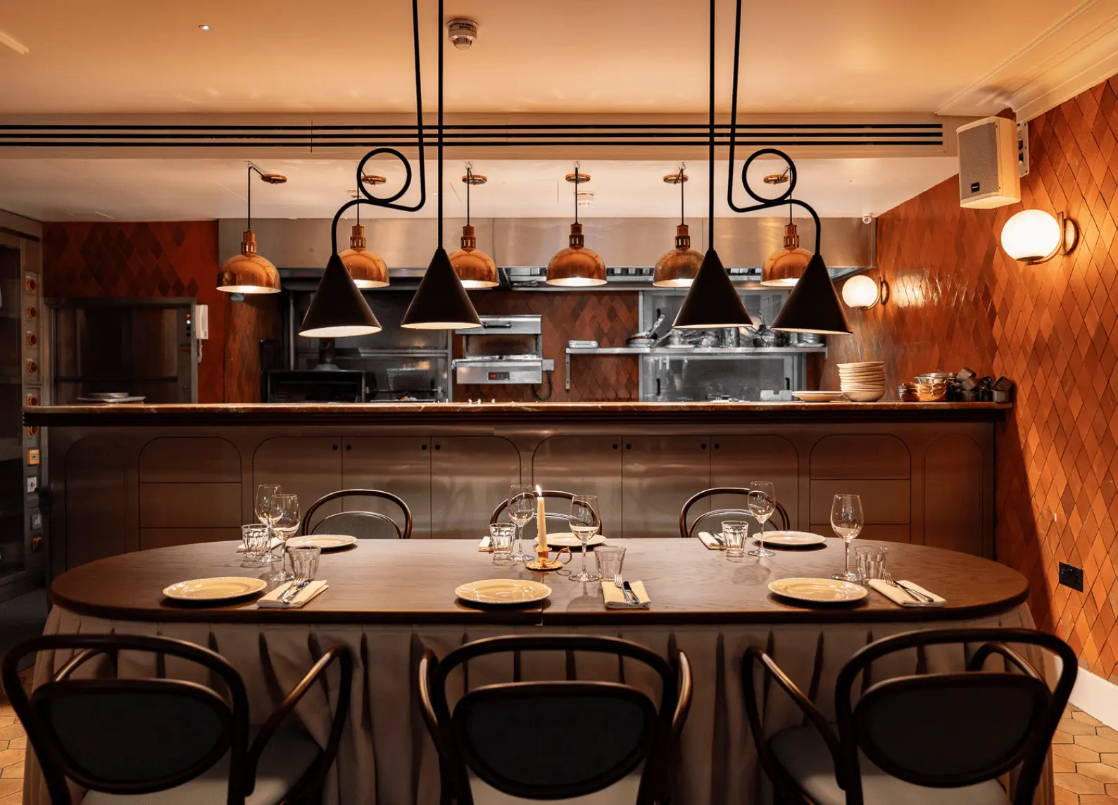 Chef's Table, tavolo con cucina a vista e lampade a sospensione in rame all'Henrietta Experimental, Covent Garden, Londra.