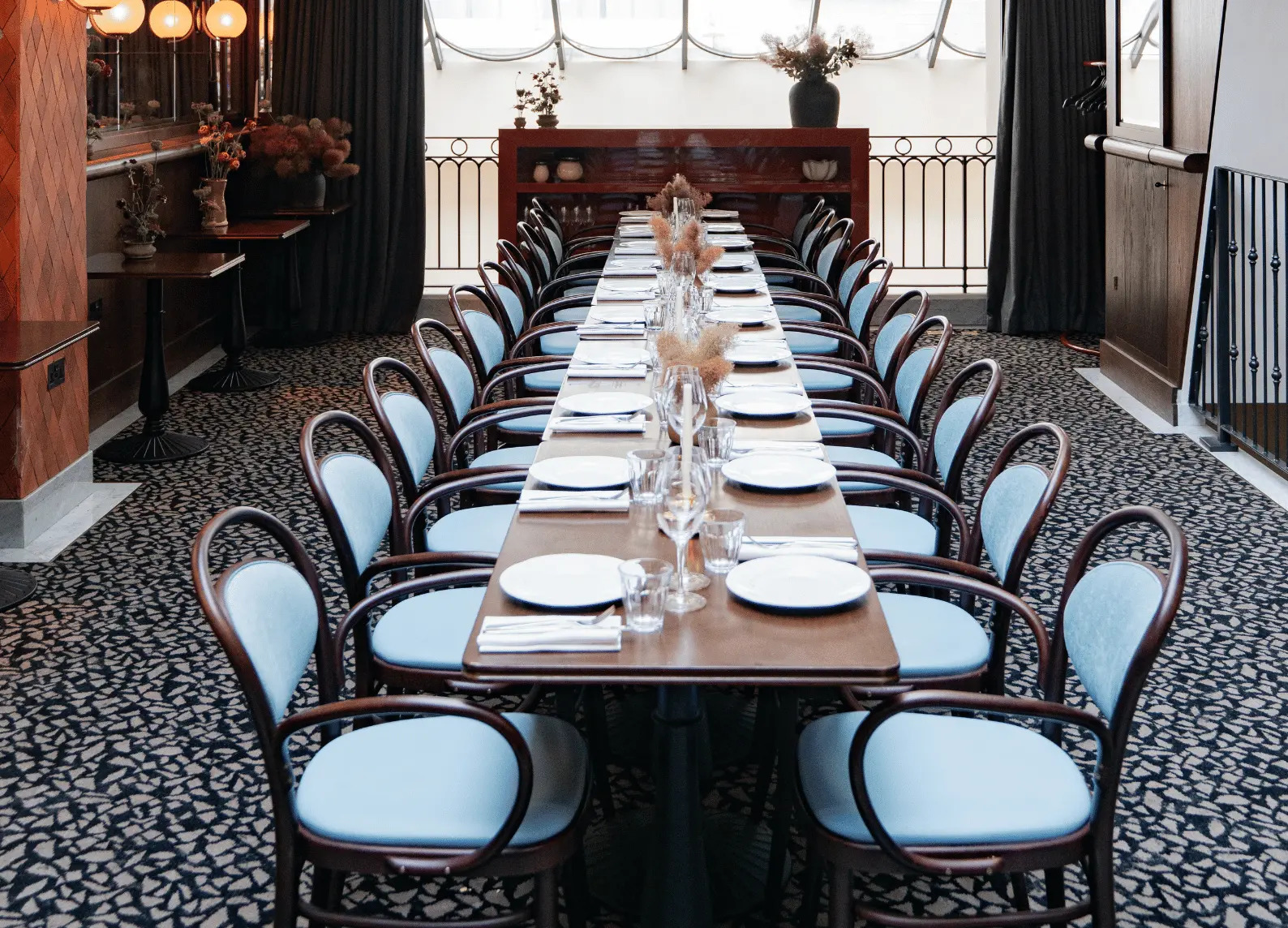 Lungo tavolo da pranzo privato con sedie blu su moquette a motivi, The Mezzanine, Henrietta Experimental, Covent Garden, Londra.