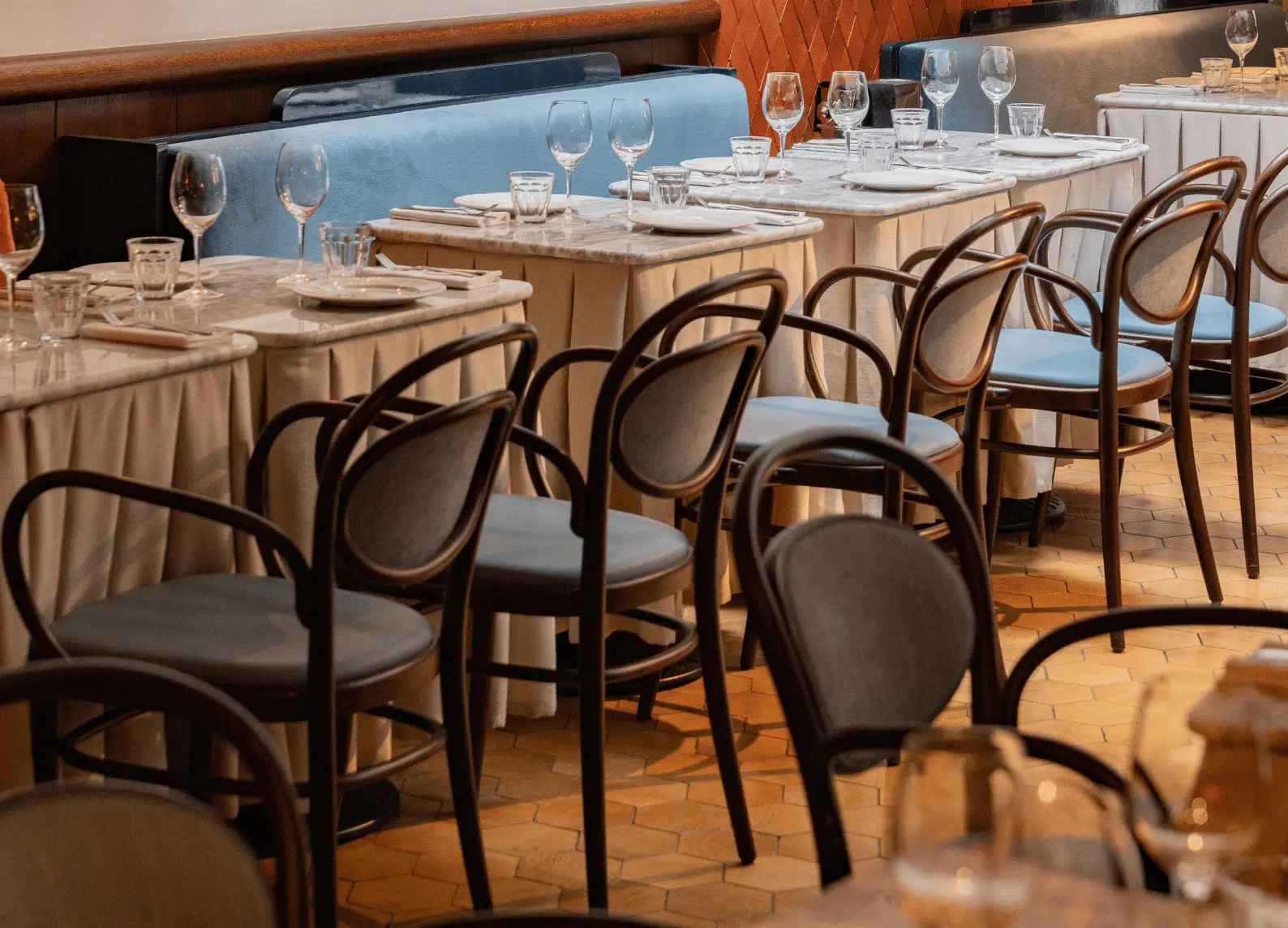 Sala da pranzo con divani blu e tavoli in marmo all'Henrietta Experimental, Covent Garden, Londra.