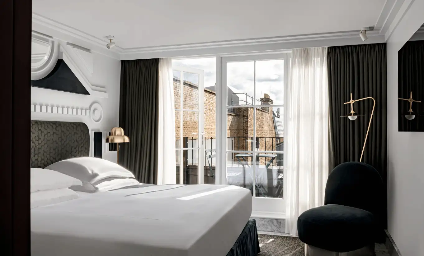Bedroom with a white double bed, dark walls and a private terrace with views over central London in the London Eye Superior Terrace room at Henrietta Experimental, boutique hotel in Covent Garden