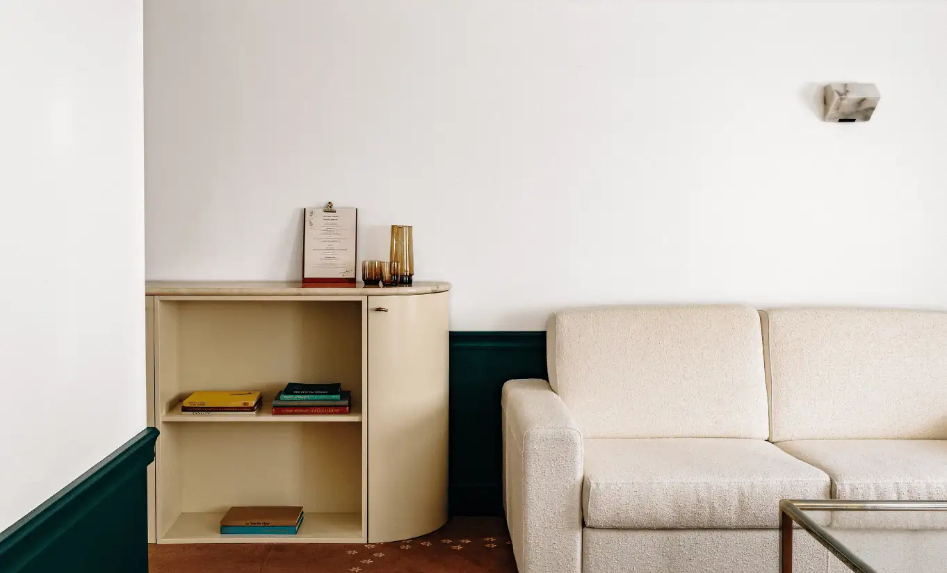 Compact living area with a beige sofa and wooden shelving in the Junior Suite at Experimental Chalet Verbier