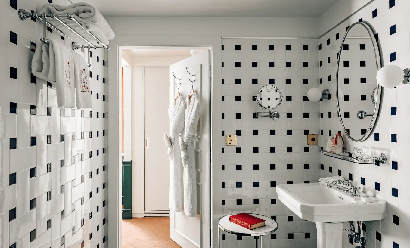 Bathroom with geometric black and white tiled walls and a walk-in shower in the Classic Room at Experimental Chalet Verbier