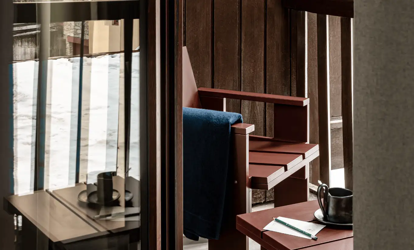 Balcon privé avec table bistrot et chaises donnant sur les montagnes dans la Junior Suite Solaise de l'Experimental Chalet Val d'Isère
