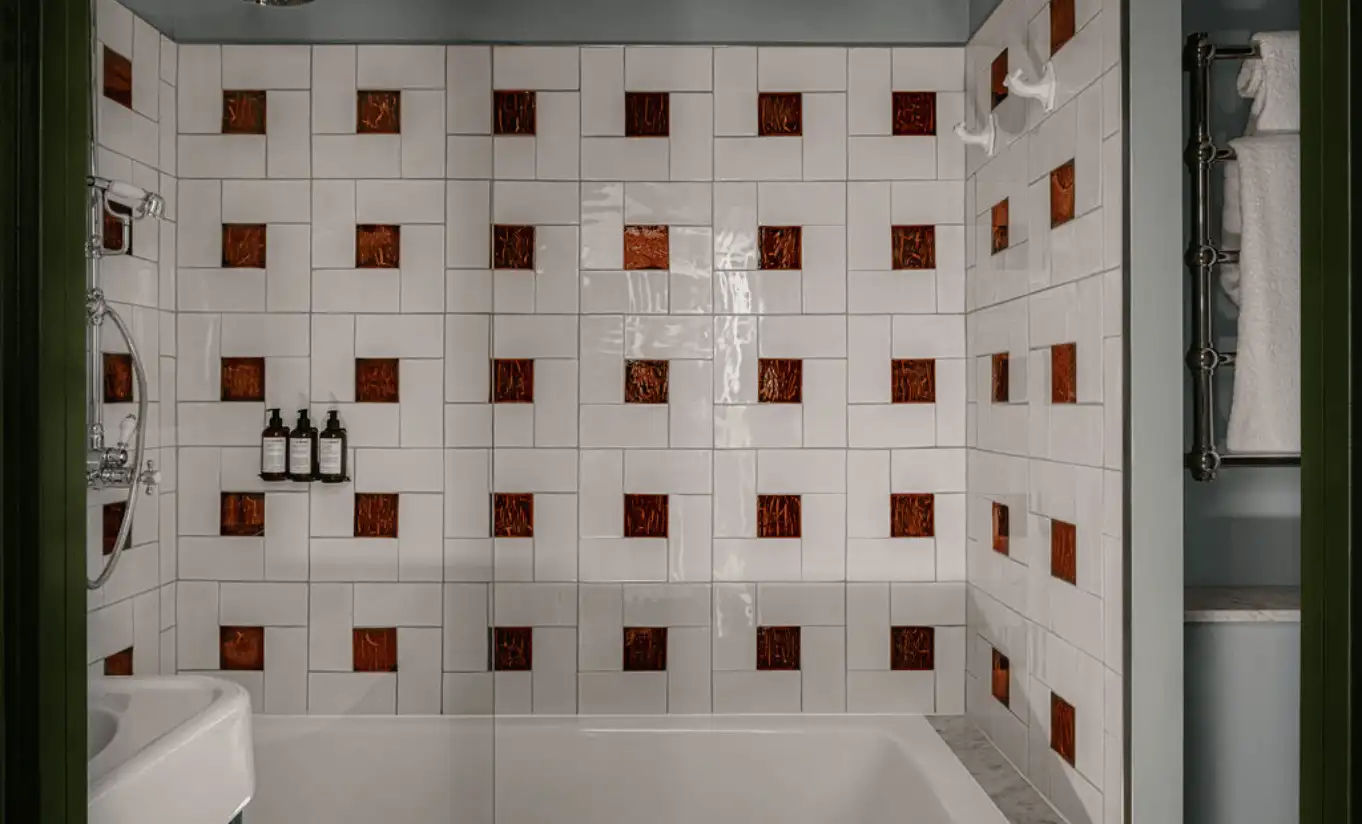 Salle de bain avec carrelage géométrique marron et blanc et baignoire îlot dans l'Olympique Deluxe de l'Experimental Chalet Val d'Isère