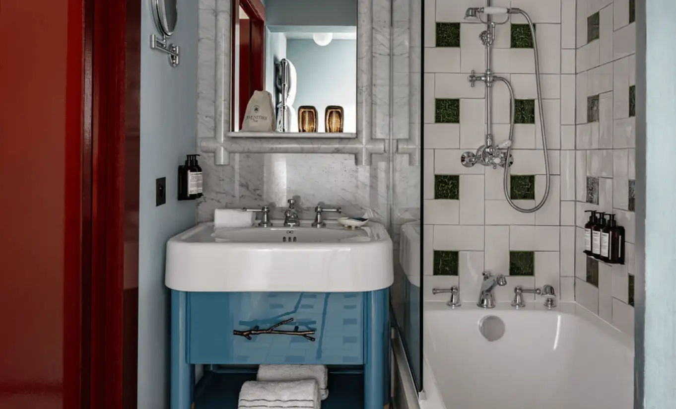 Bathroom with geometric black and white tiles, a blue basin and a walk-in shower in the Val d'Isère Balcony at Experimental Chalet Val d'Isère