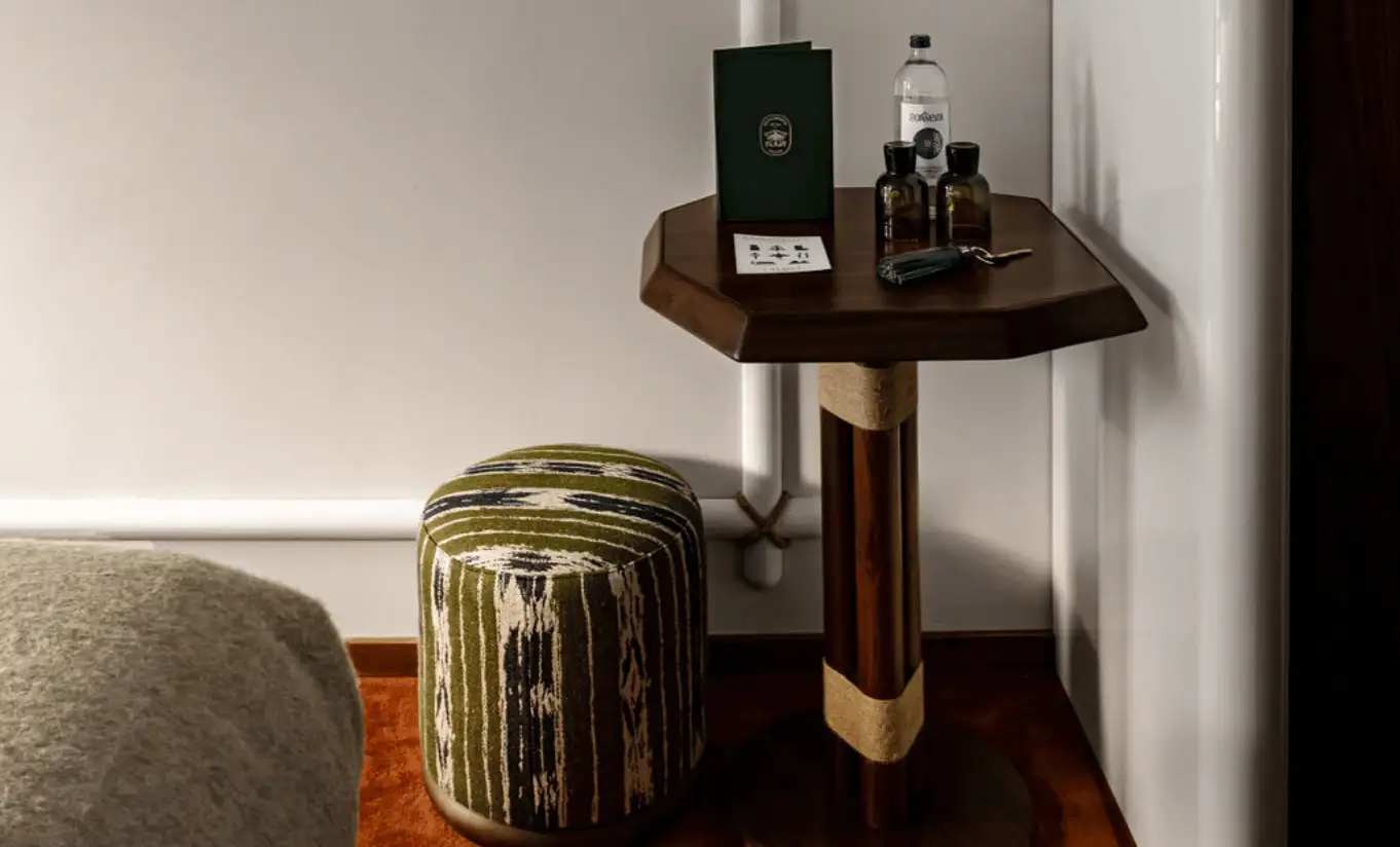 Wooden bedside table with spa products and a green vase in the Val d'Isère Balcony at Experimental Chalet Val d'Isère