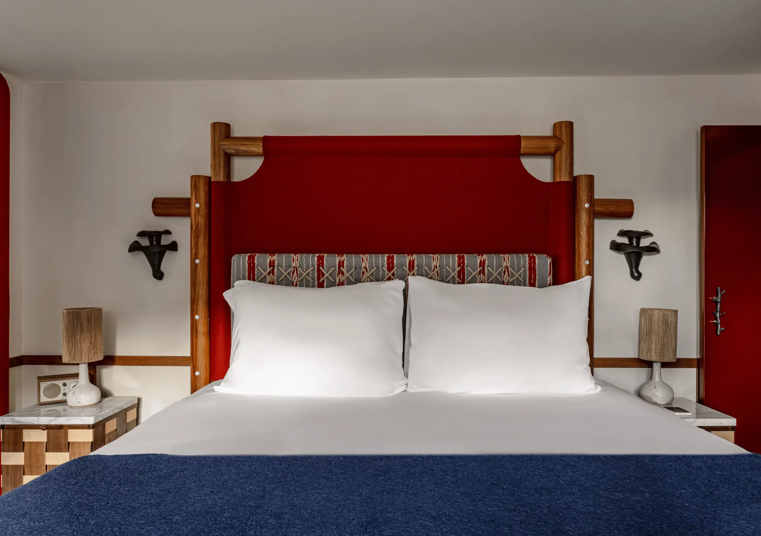 Bedroom with a white double bed, red headboard and wooden bedside tables in the Bellevarde Suite at Experimental Chalet Val d'Isère, luxury spa hotel in the French Alps