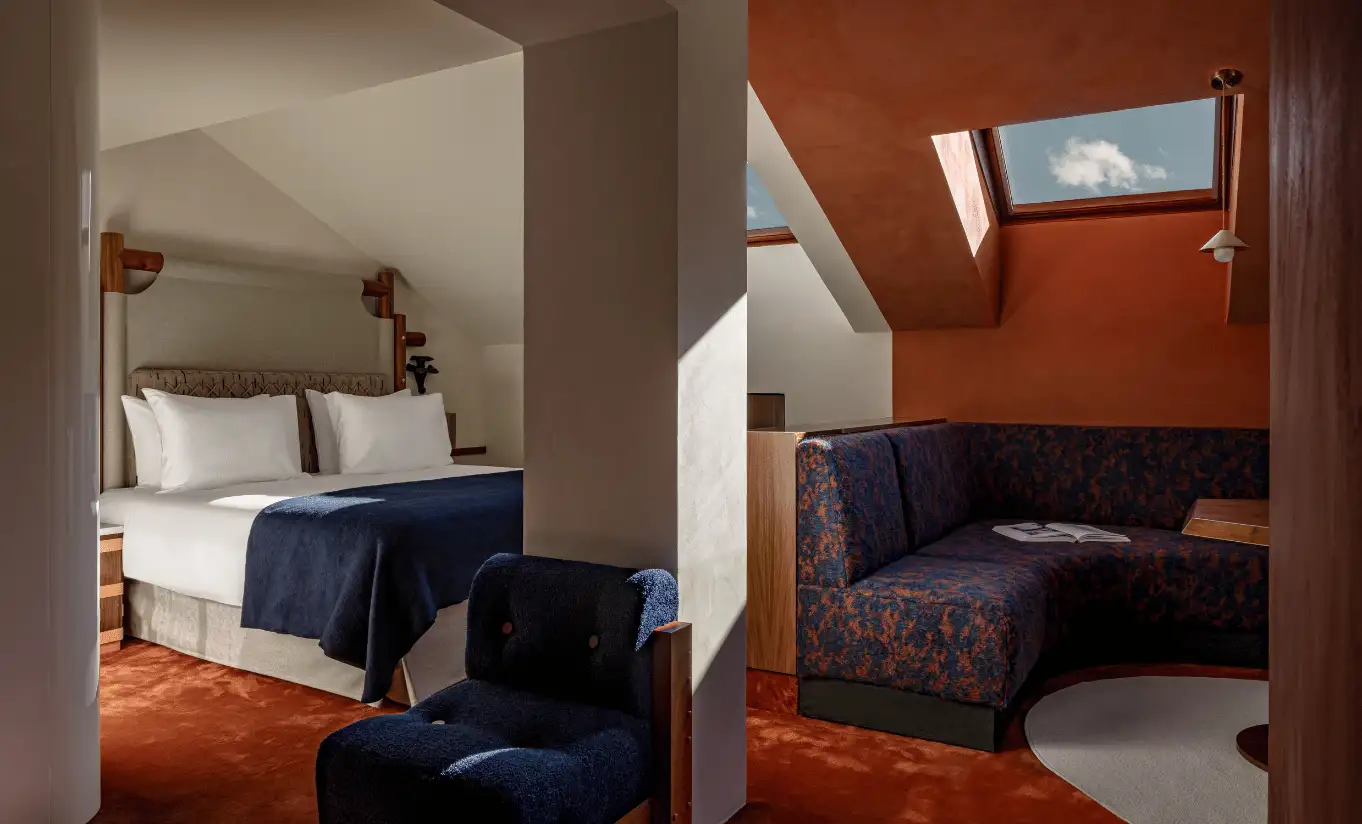 Attic bedroom with terracotta walls, a blue sofa and a skylight in the Solaise Suite at Experimental Chalet Val d'Isère, luxury ski hotel in the French Alps