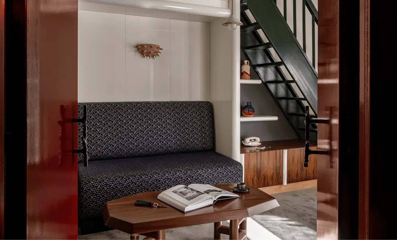 Mezzanine living area with a dark sofa, wooden coffee table and a staircase in the Loft with Balcony at Experimental Chalet Val d'Isère