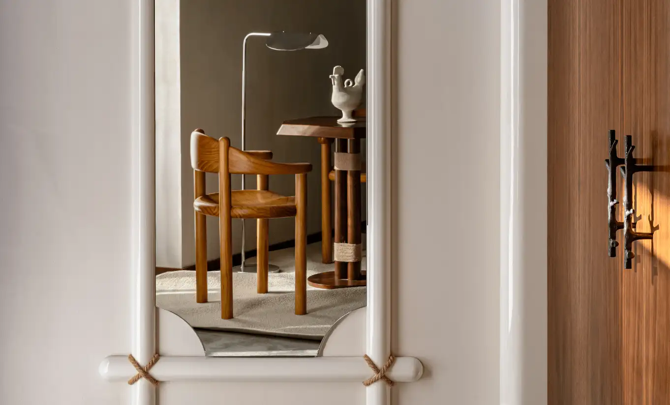 Close-up of a vintage mirror reflecting a wooden bathroom interior in the Loft at Experimental Chalet Val d'Isère