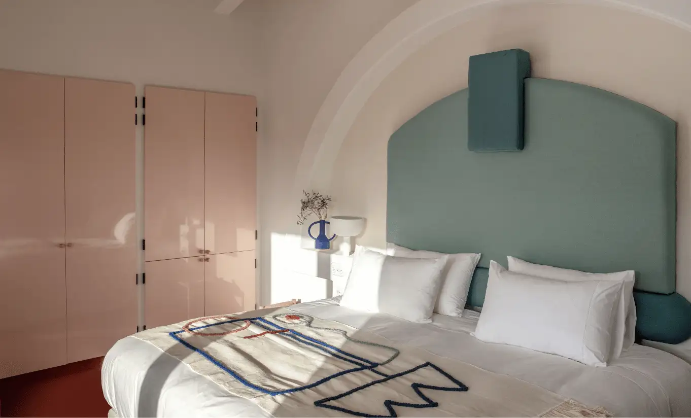 Cozy bedroom with sage green vaulted ceiling, white bedding and soft ambient lighting at Menorca Experimental hotel, Experimental Group.