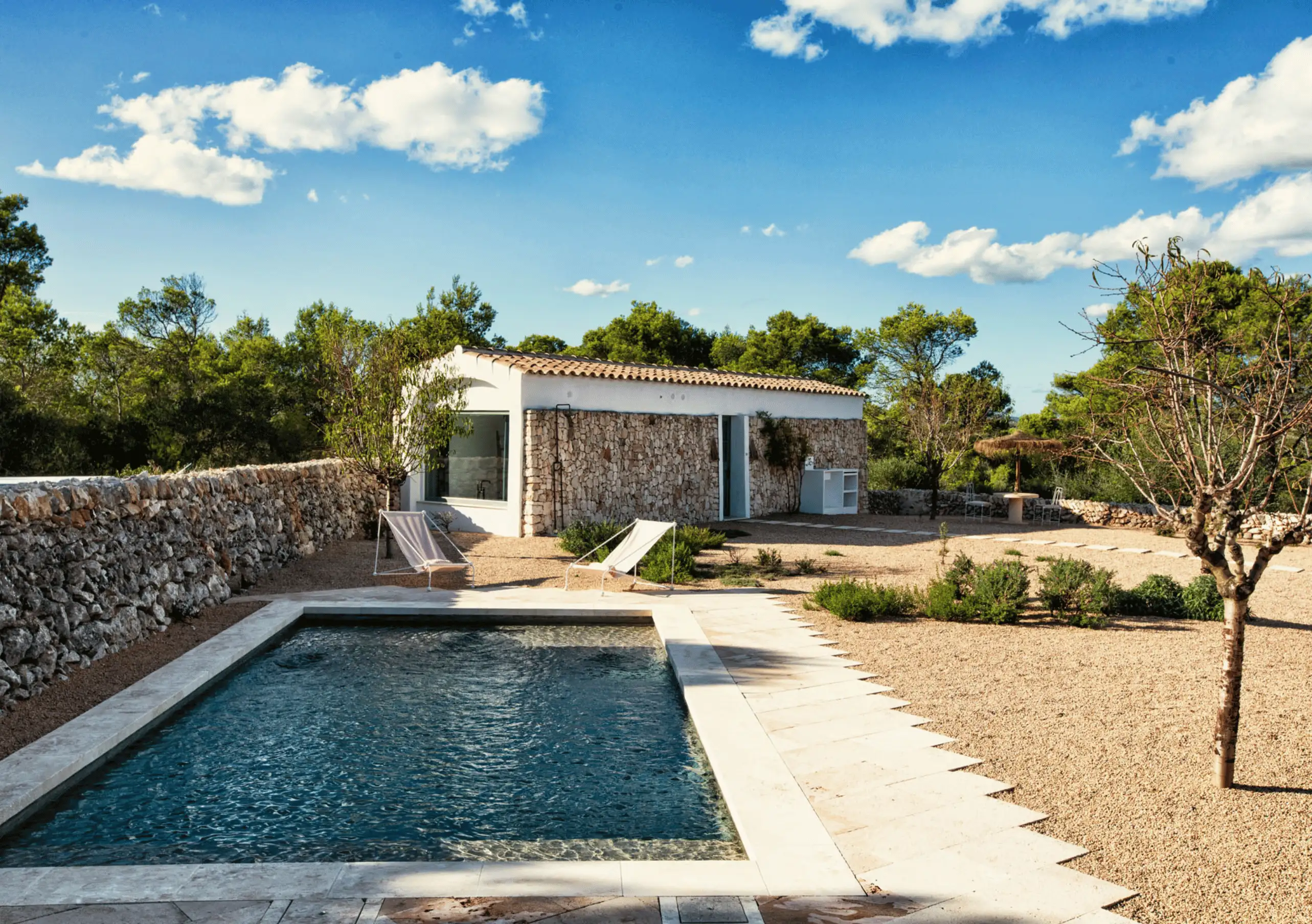 Menorca Experimental by Experimental Group – private pool with contemporary cabana and traditional dry stone walls amid Mediterranean scrubland.