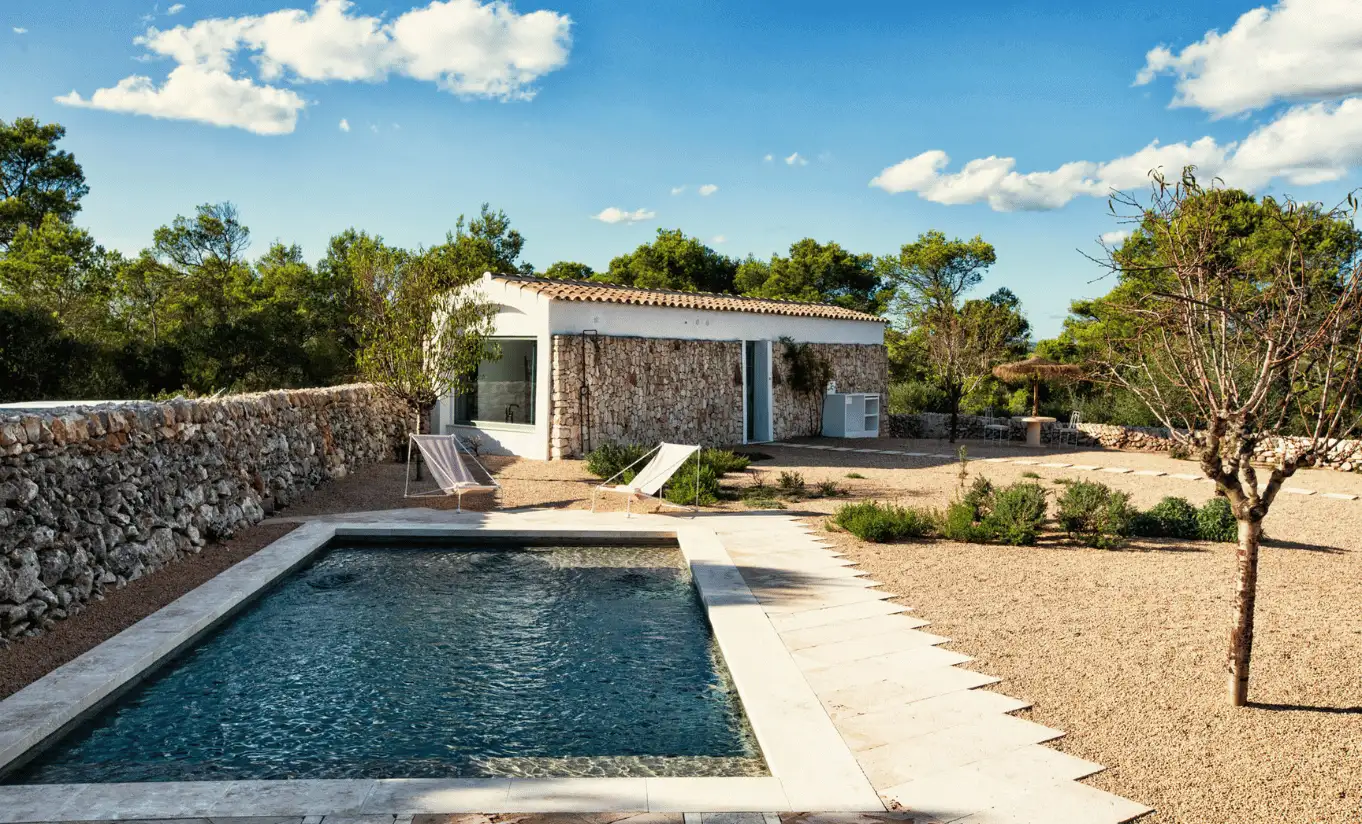 Menorca Experimental by Experimental Group – private pool with contemporary cabana and traditional dry stone walls amid Mediterranean scrubland