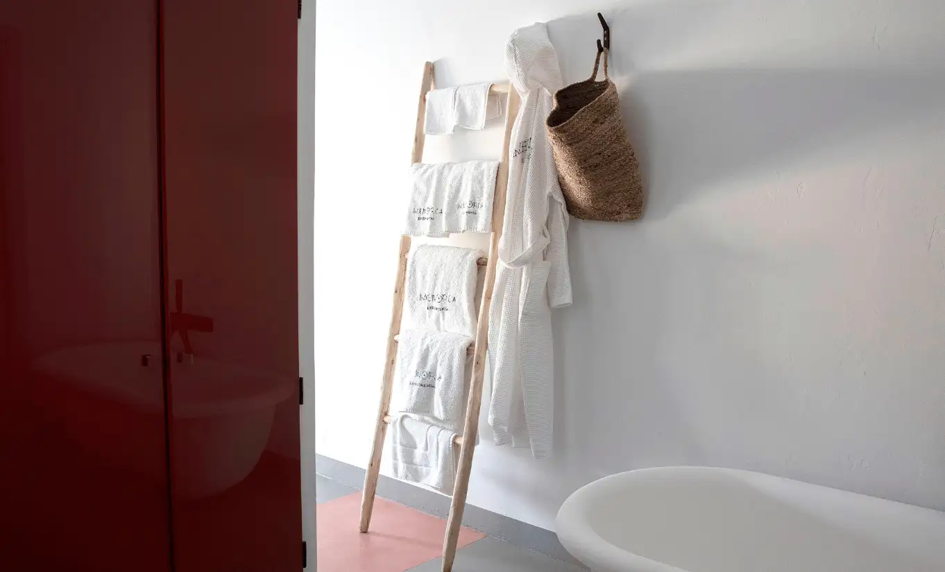 Menorca Experimental Experimental Group entrance detail with wooden ladder towel rack against bold red lacquered wall