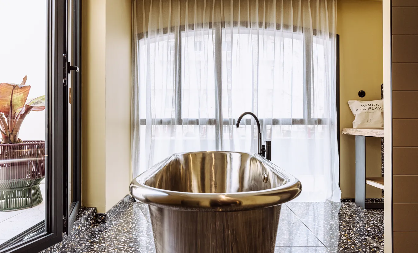 Experimental Group hotel luxury bathroom with copper freestanding soaking tub and sheer curtains