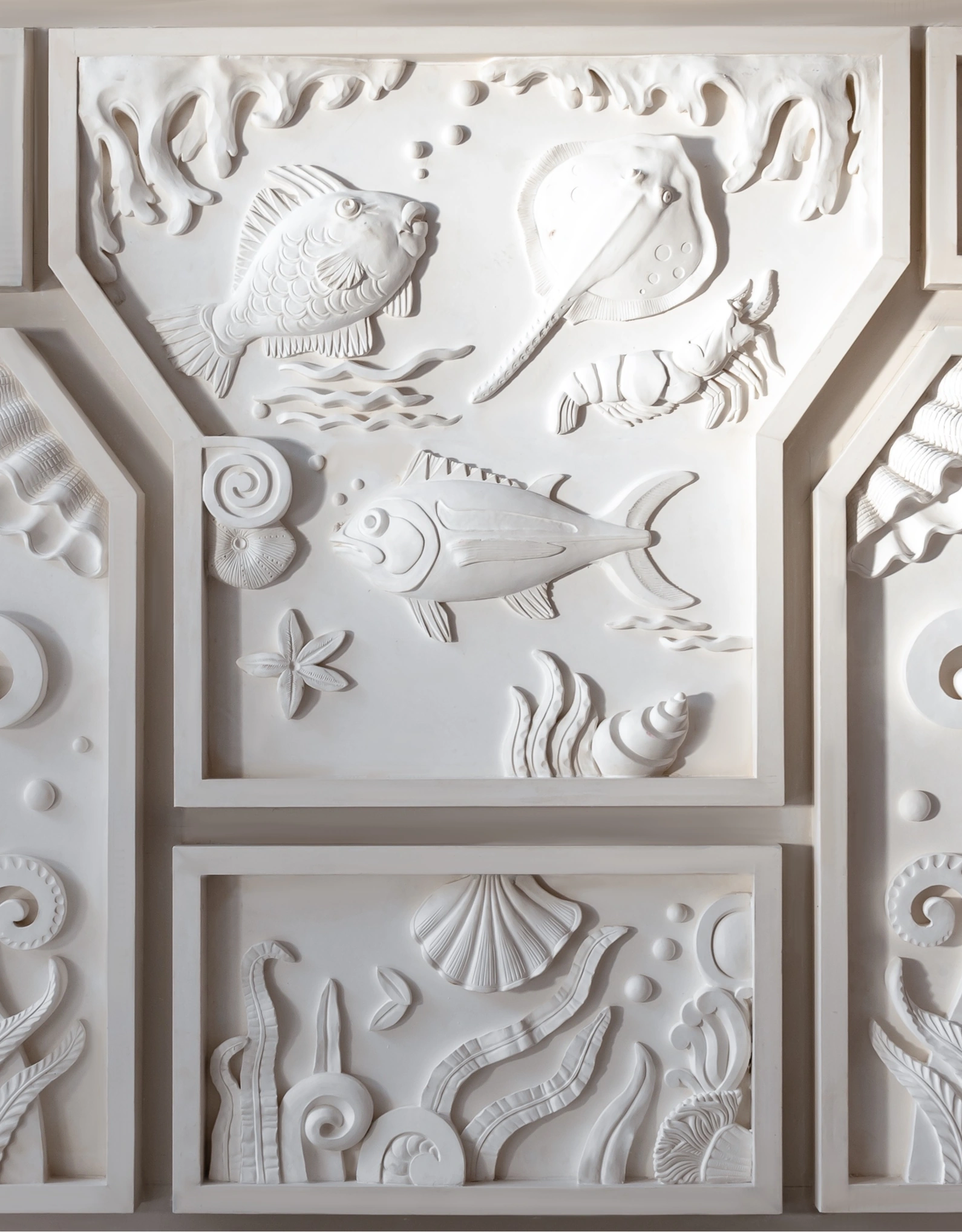 Wall bas-relief featuring marine motifs, illustrating the narrative and immersive design of the Experimental Group.