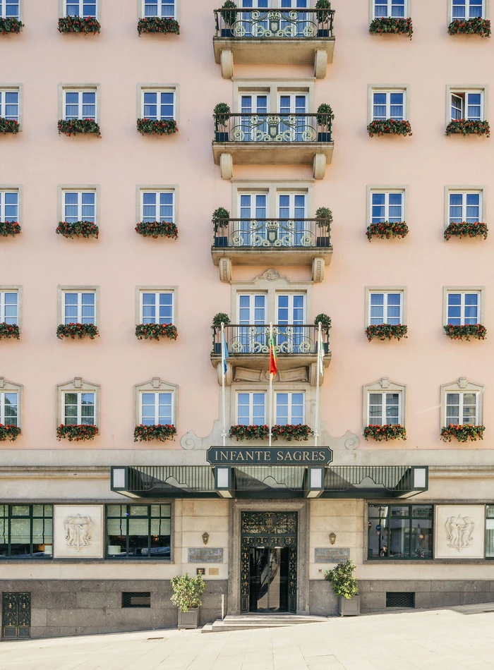 Gros plan sur la façade d'une entrée historique d'Hôtel , avec ses balcons décoratifs et ses fenêtres à la disposition symétrique.