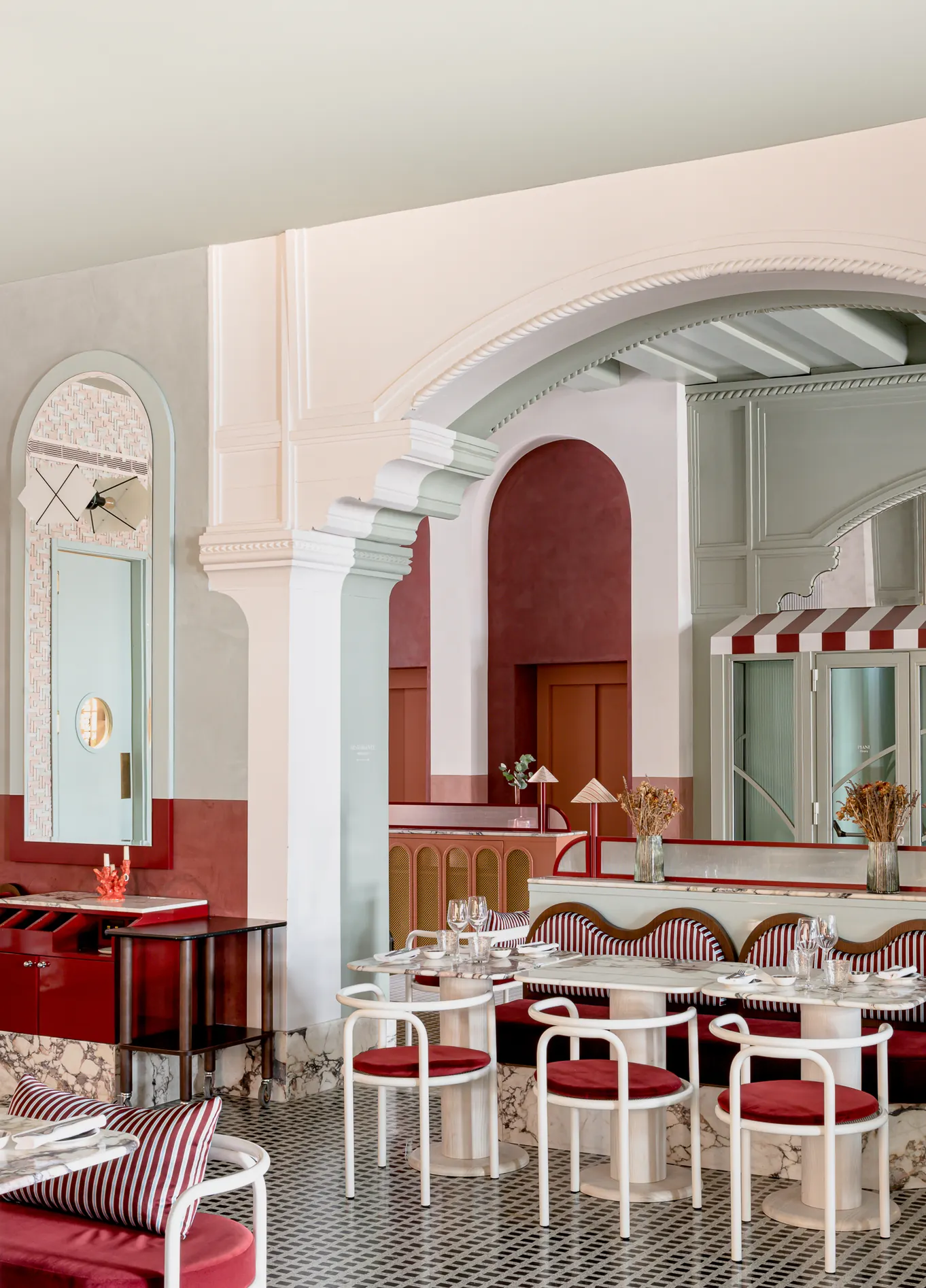 Sala de jantar luminosa com arcos brancos e cadeiras vermelhas no elegante restaurante Adriatica, Veneza