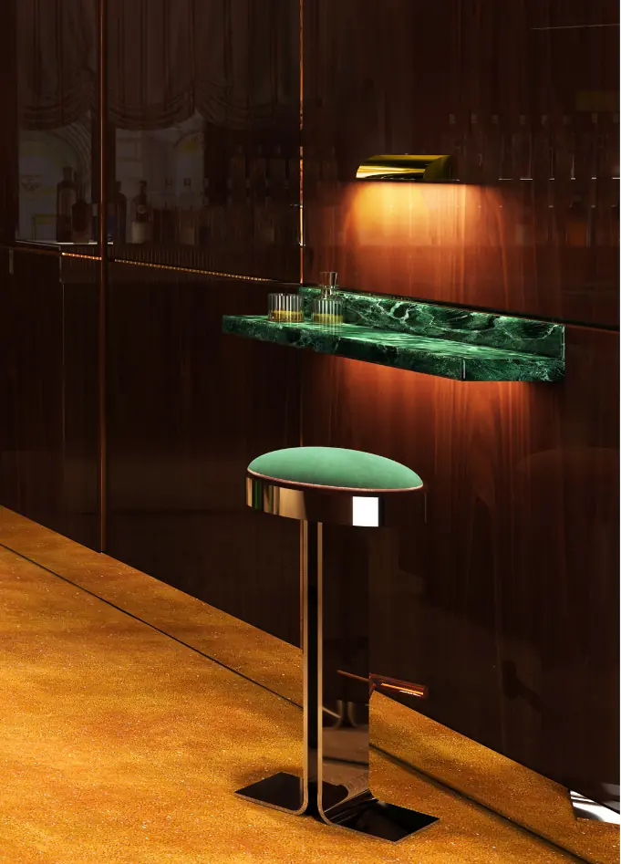 Detail shot of a sophisticated bar area with a single stool and a floating green marble shelf under soft lighting.