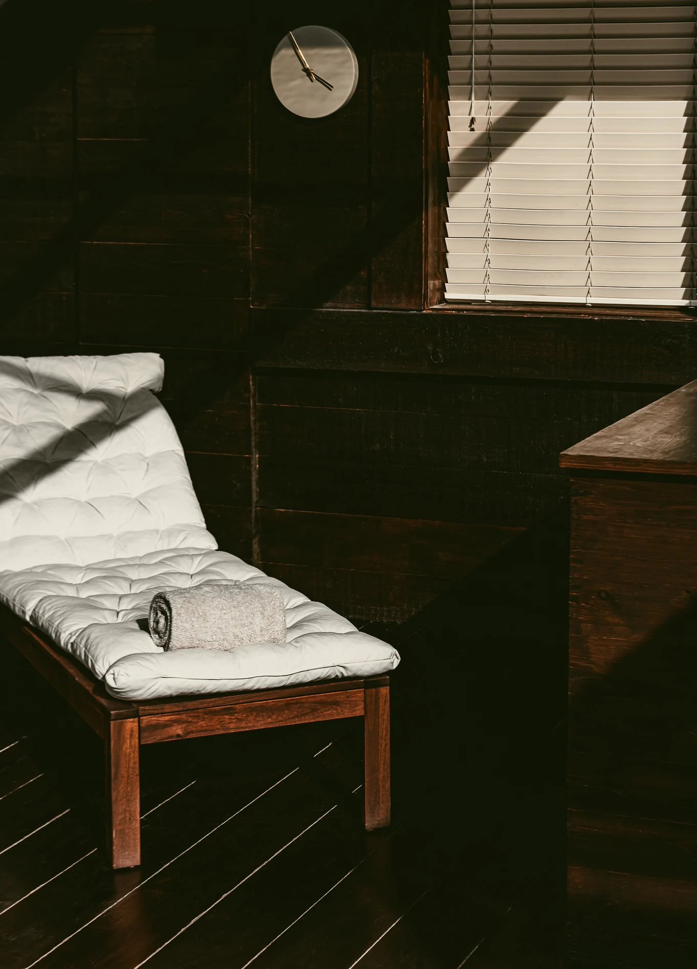 Uma chaise longue branca num quarto com paredes escuras e um ambiente acolhedor no hotel Experimental Chalet Verbier.