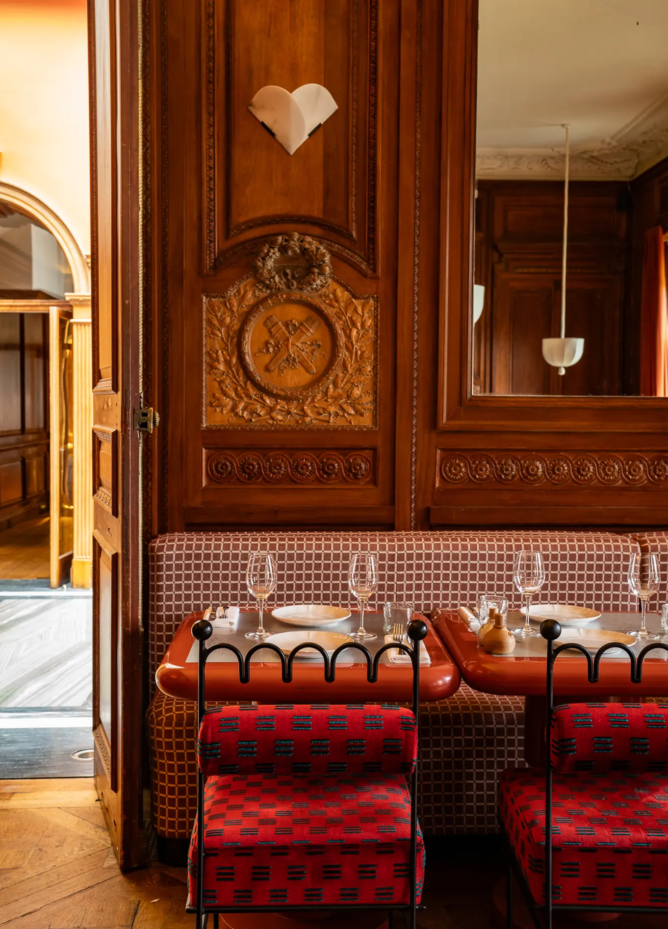 Elegante sala de jantar com painéis de madeira e cadeiras vermelhas no restaurante Cowley Manor, Cotswolds